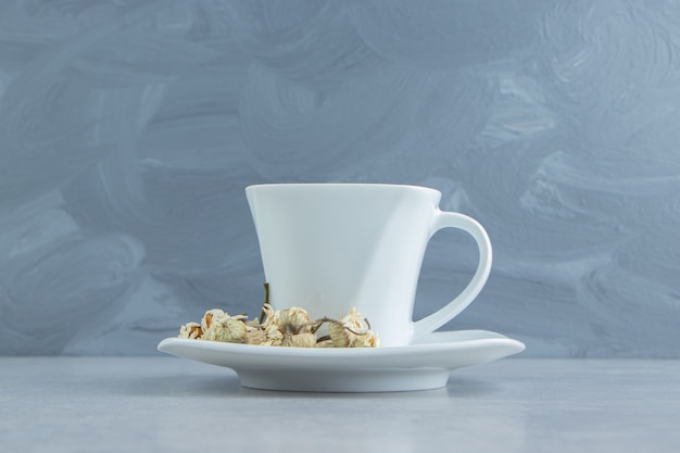 Cup of tea with dried chamomile flowers