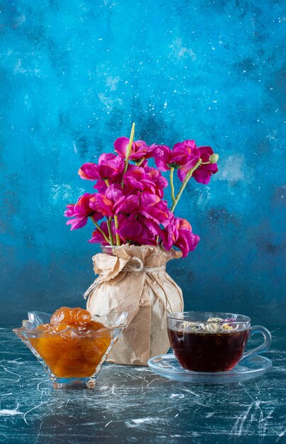 A cup of tea with fig confiture in the saucer.