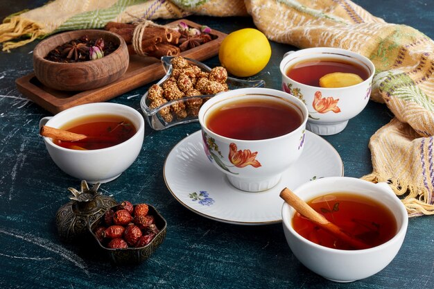 A cup of tea with fruits, sweets and spices.