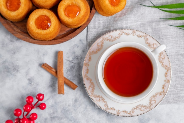 A cup of tea with homemade apricot jam thumbprint cookies.