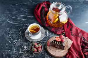 Foto gratuita una tazza di tè con torta al limone e cioccolato.