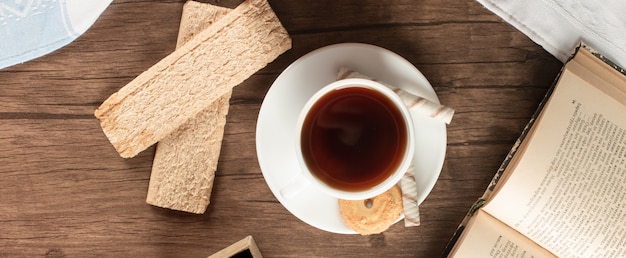 A cup of tea with some crispy crackers. top view