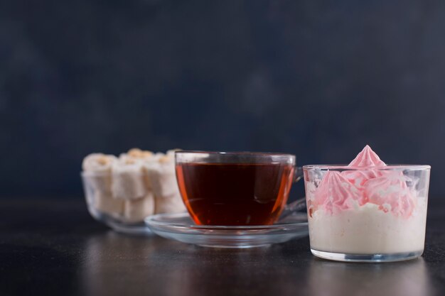 A cup of tea with turkish lokum and marshmallows, angle view.