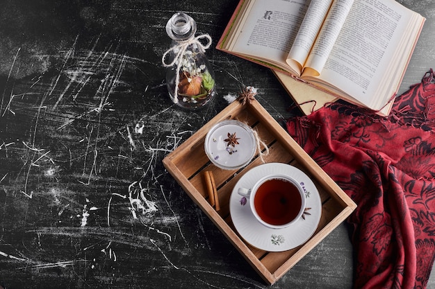 A cup of tea in a wooden tray, top view. 