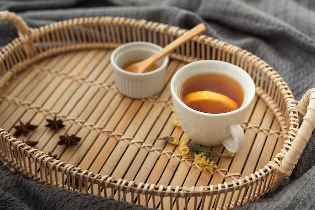 Cup of tea on wooden tray with honey