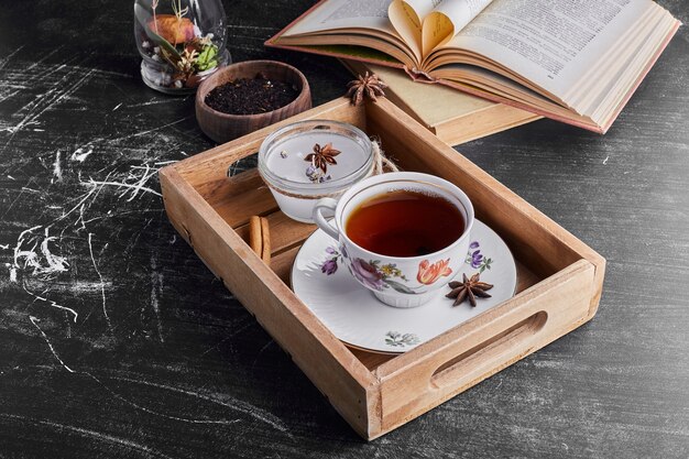 Чашка чая в деревянном подносе.