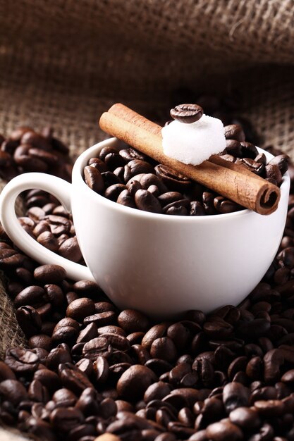 Cup with coffee beans and cinnamon stick