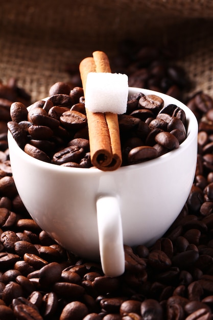 Cup with coffee beans and cinnamon stick