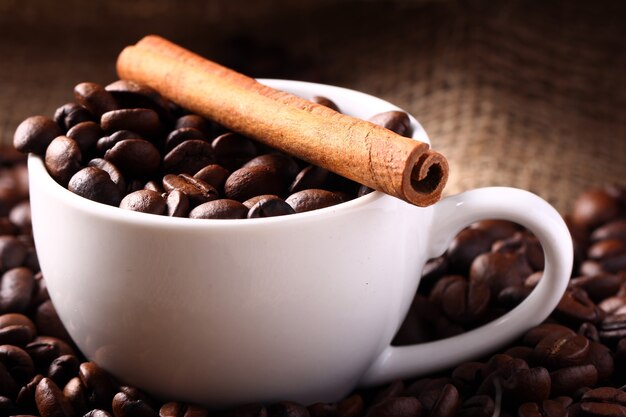 Cup with coffee beans and cinnamon stick