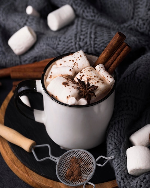 Cup with marshmallow drink cinnamon flavor on wooden board