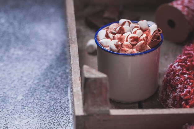 Cup with marshmallows on a wooden tray