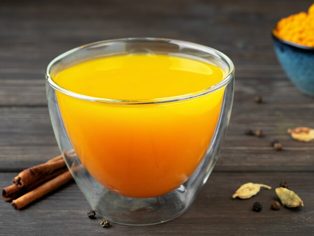 Cup with natural healthy herbal tea made from turmeric, honey and spices