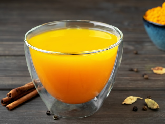 Cup with natural healthy herbal tea made from turmeric, honey and spices