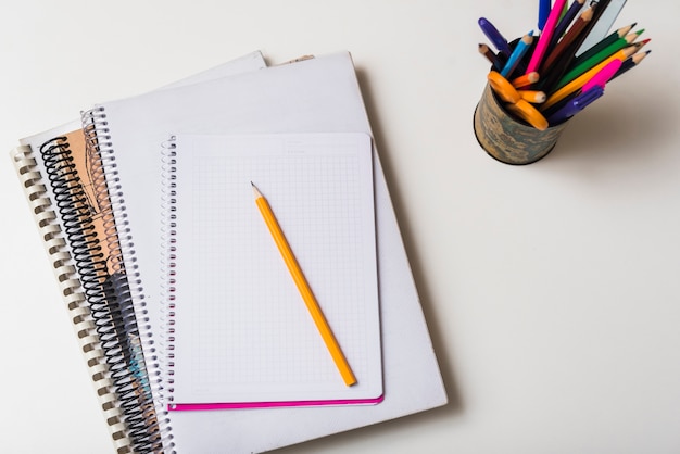 Cup with pencils near notepads