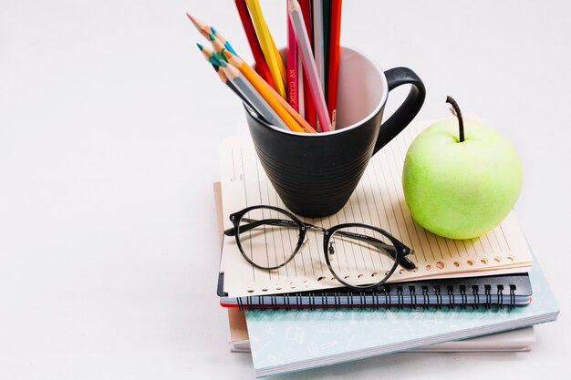 Cup with pencils on notebooks