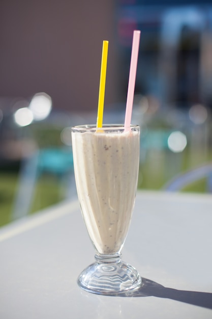 Cup with a smoothie with two straws