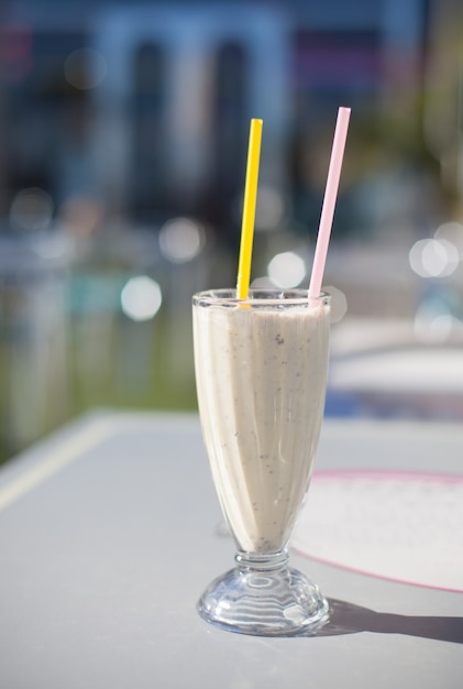 Cup with a smoothie with two straws