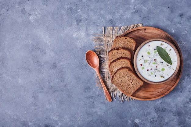 A cup of yogurt soup served with bread slices.