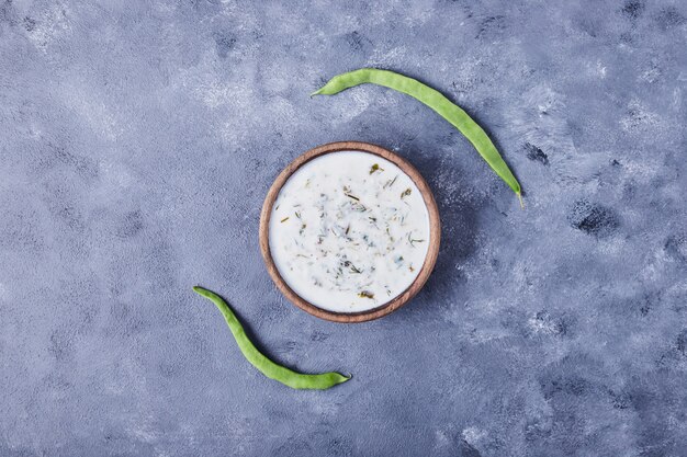 A cup of yogurt soup with green beans.