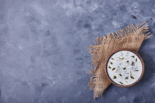 A cup of yogurt soup with herbs and spices.