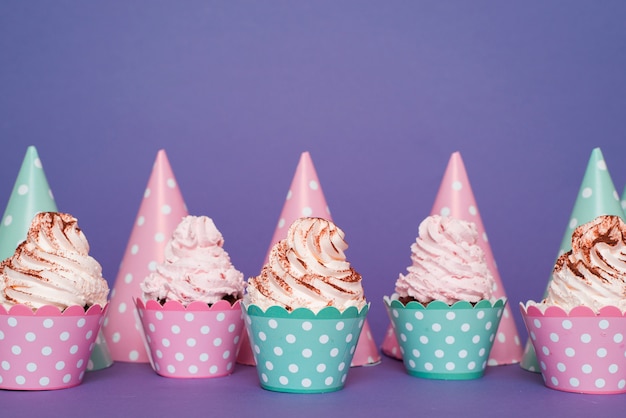 Foto gratuita linea di cupcake e cappelli