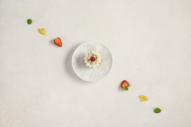 Free photo cupcake on a plate surrounded by a line of fruits