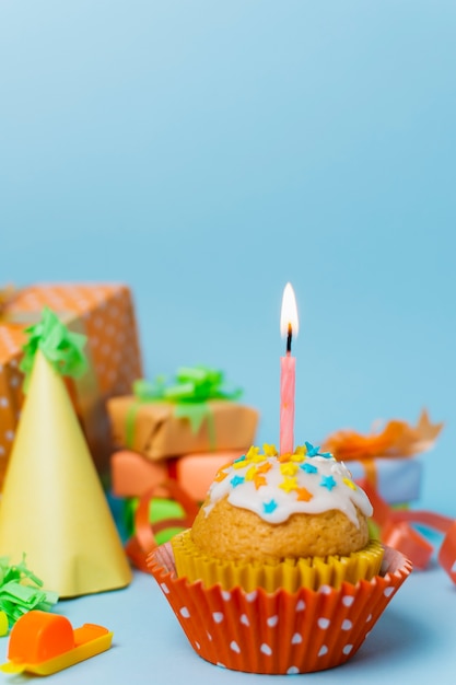Кекс с зажженной свечой и днем рождения