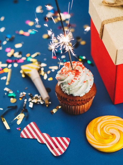 Free photo cupcake with sparkler at confetti