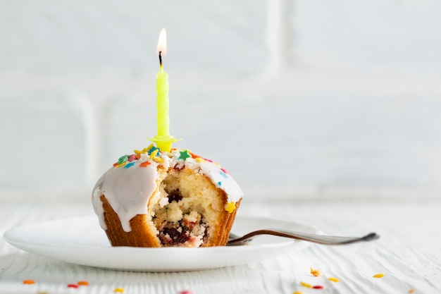 Cupcake with white glaze and candle