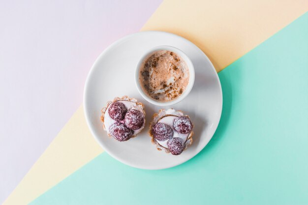 Cupcakes and coffee on tri colored background