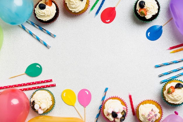 Cupcakes with air balloons and candles on table