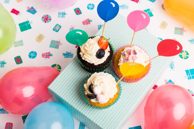 Cupcakes with balloon toppers on box