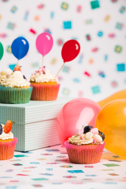 Cupcakes with balloons on table 