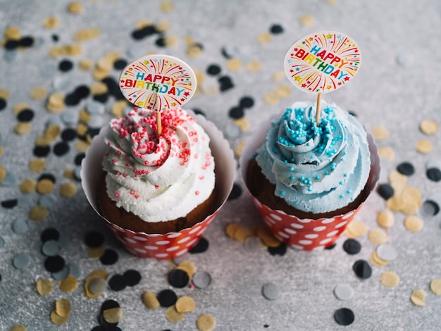 Foto gratuita cupcakes con crema colorata e segni di buon compleanno