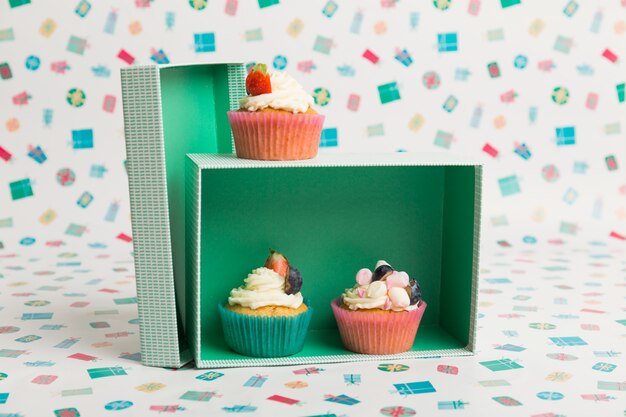 Cupcakes with cream and berries on table 