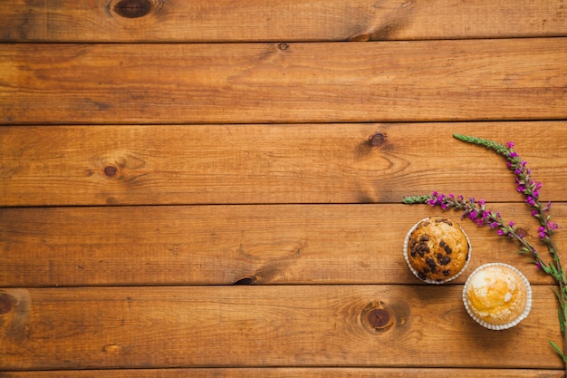 Free photo cupcakes with flowers on wood