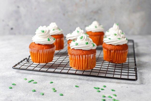 cupcakes with green decorations on wood table