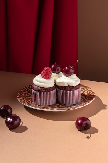 Cupcakes with raspberry and cherry on plate