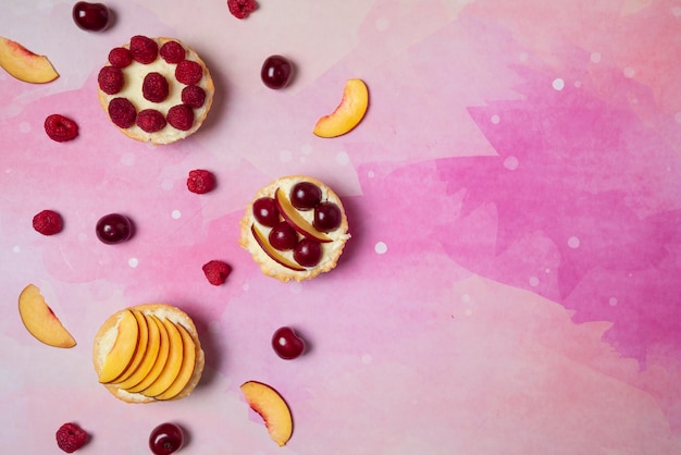 Cupcakes with vanilla cream and summer fruits on the top