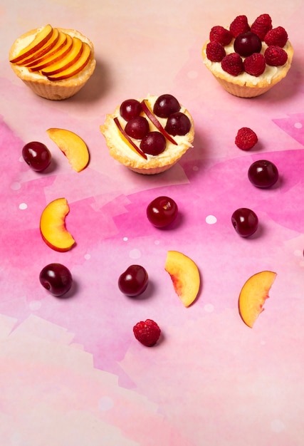 Cupcakes with vanilla cream and summer fruits on the top