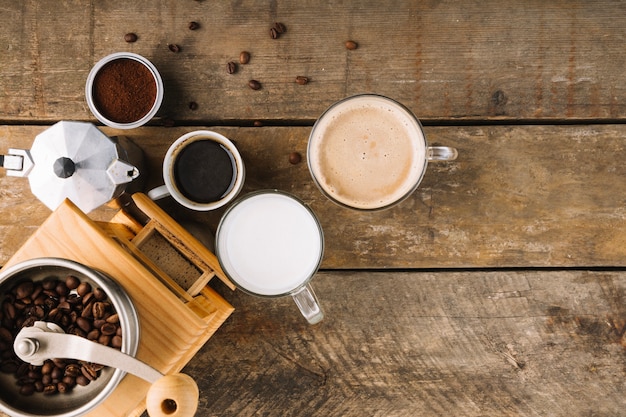 Cups of coffee near grinder