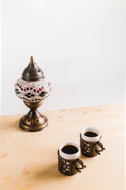 Cups of coffee near tableware on table