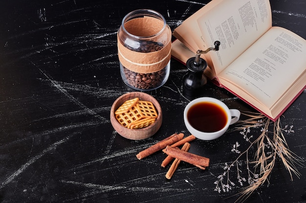 Cups of coffee with biscuit and cinnamons.