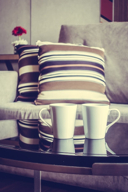 Free photo cups of coffee with cushions behind