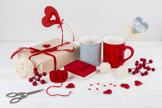 Cups with hearts on wands near little hearts, scissors and presents