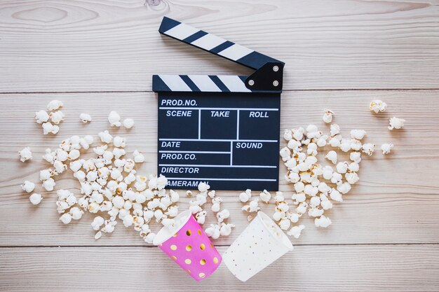 Cups with popcorn and clapboard