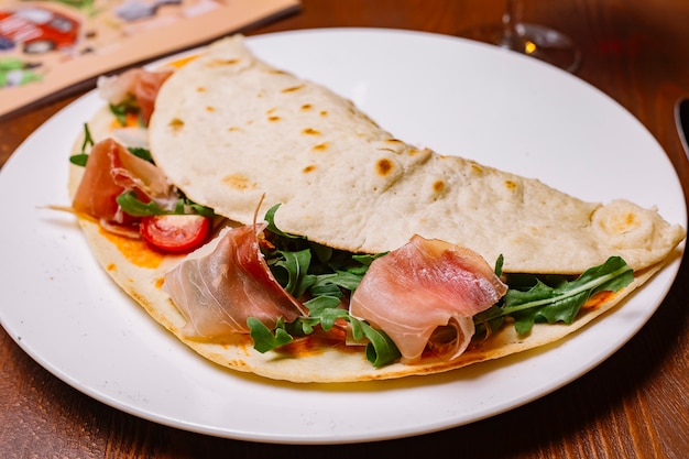 Cured meat wrap with rocket cherry tomato and tomato sauce