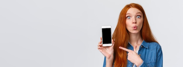 Free photo curious and amused lovely redhead woman with long red hair folding lips intrigued and excited discus