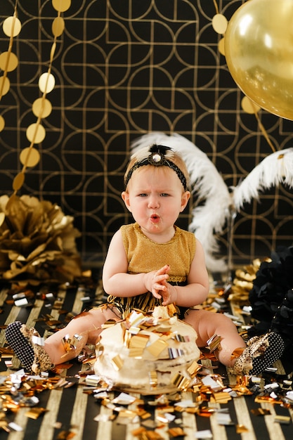 Free photo curious baby girl poking finger in her first birthday cake smash.
