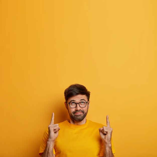 Curious bearded man indicates upwards